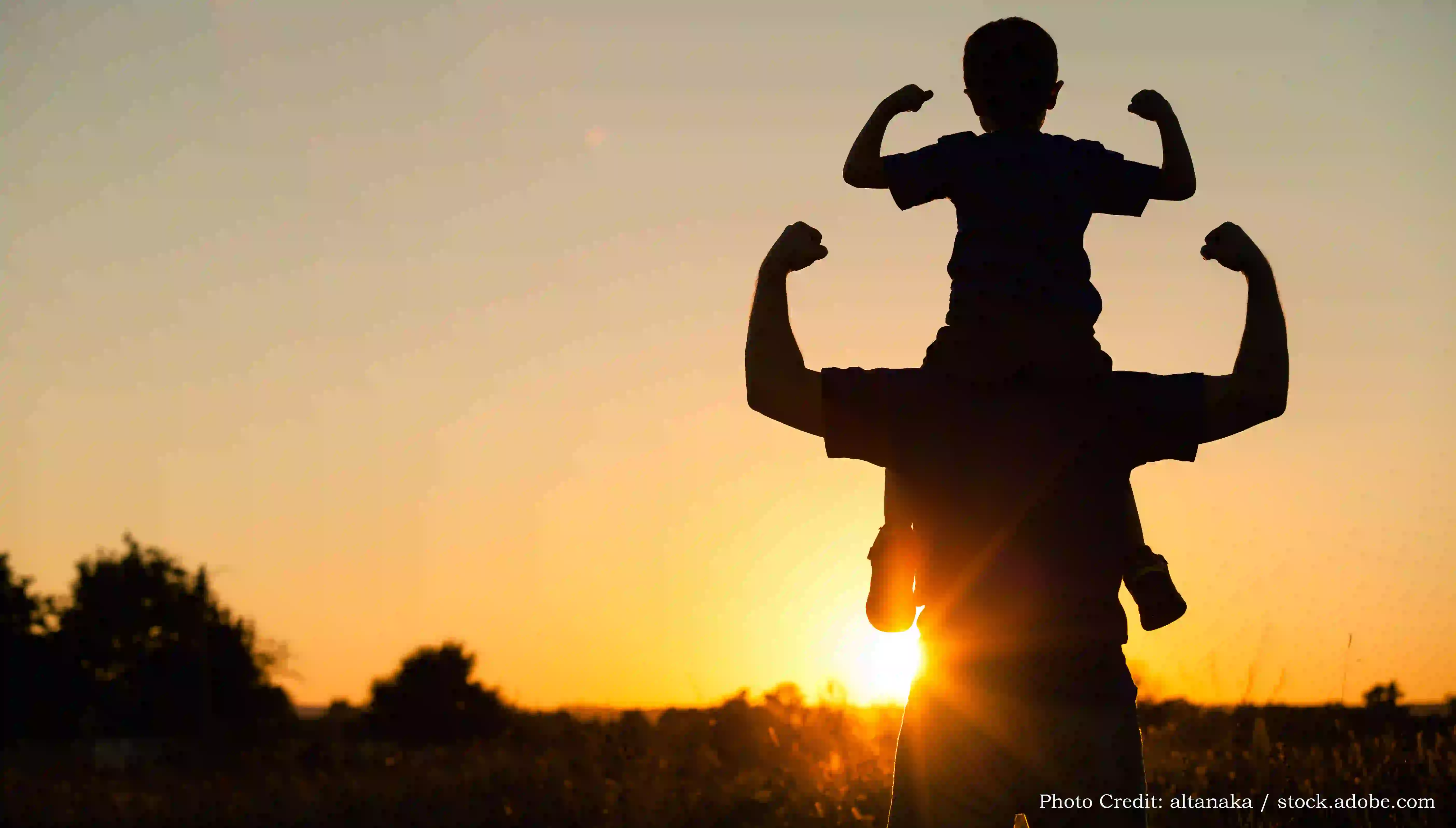 Father and son playing in the park at the sunset time